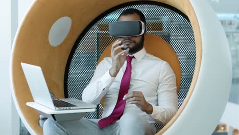 Businessman-using-vr-headset-and-laptop